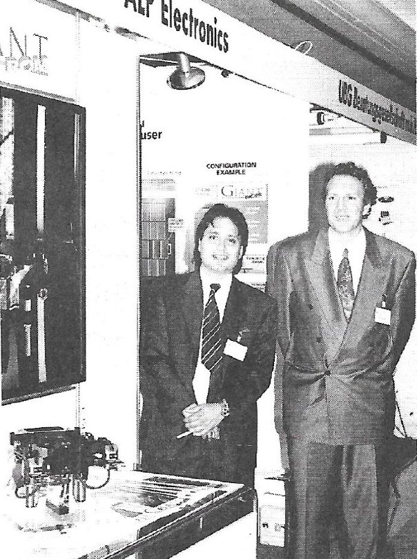 Dominique Pisino y Andreas Forrer, de la empresa suiza ALP Electronics. Abajo a la izquierda puede observarse un mecanismo de aparato lector de cd-roms.